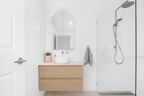 Thirroul ensuite renovation by Bros Built, curved mirror, textured gloss tiles, wood vanity with round sink