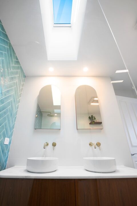 Bros. Built bathroom renovation Woonona with skylight, double arch mirrors and double basin